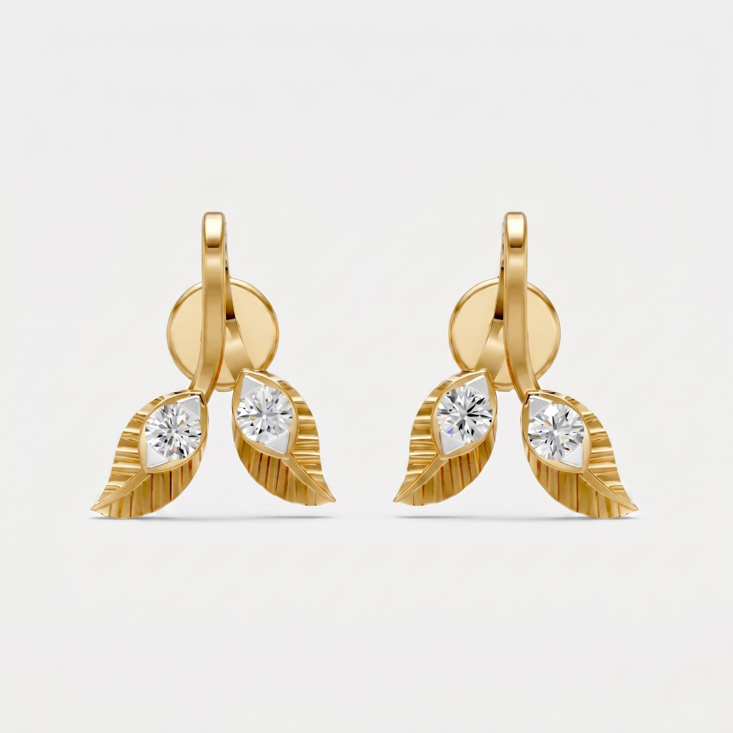 A pair of gold leaf drop earrings with marquise-cut clear gemstones, photographed against a clean, light gray background.