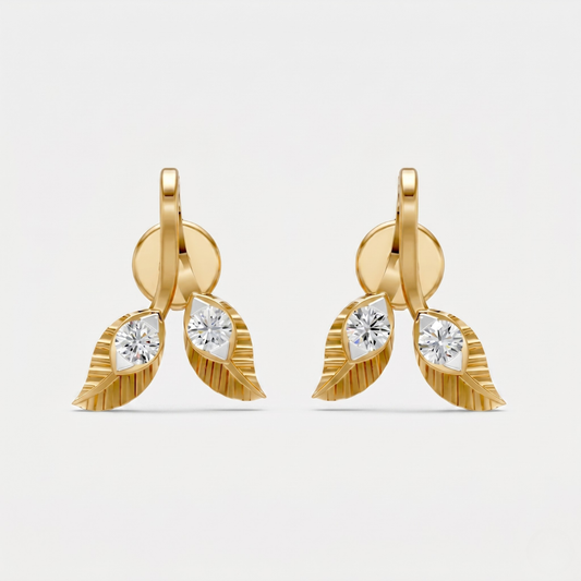 A pair of gold leaf drop earrings with marquise-cut clear gemstones, photographed against a clean, light gray background.